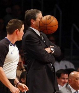 A basketball coach has been hit in the face with a ball. The photo captures the exact moment it happened.