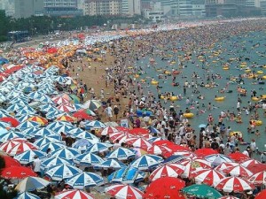 much many a lot of grammar Many umbrellas and a lot of people on a beach but not much sand.
